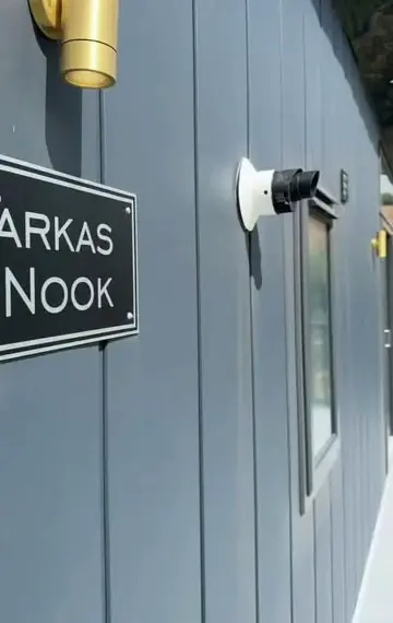 The Tarka's Nook nameplate on blue-grey cladding, with a brass outside light above.